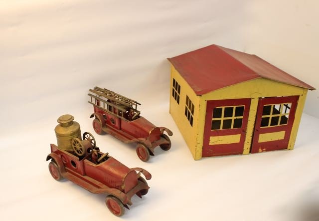 DAYTON HILL CLIMBER SET: DAYTON HILL CIMBER FIREHOUSE AND FIRETRUCKS, PRESSED STEEL FRAMES YELLOW AND RED TRIM, GOOD OVERALL CONDITION, MINOR PAINT LOSS WEAR CONSISTEN WITH AGE, FIREHOUSE 11.5" X 16" X 16, FIRETRUCKS ARE 13.5