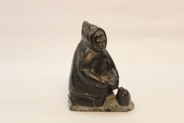 INUIT CARVED FIGURE: CARVED INUIT FIGURE WITH FIGURE AND SEAL - DATED 79 ON BOTTOM AND SIGNATURE. 6 1/4"H