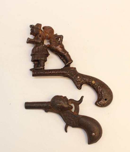 (2) CAST IRON CAP GUNS: PUNCH & JUDY AND NIGGER HEAD CAST IRON CAP GUNS.