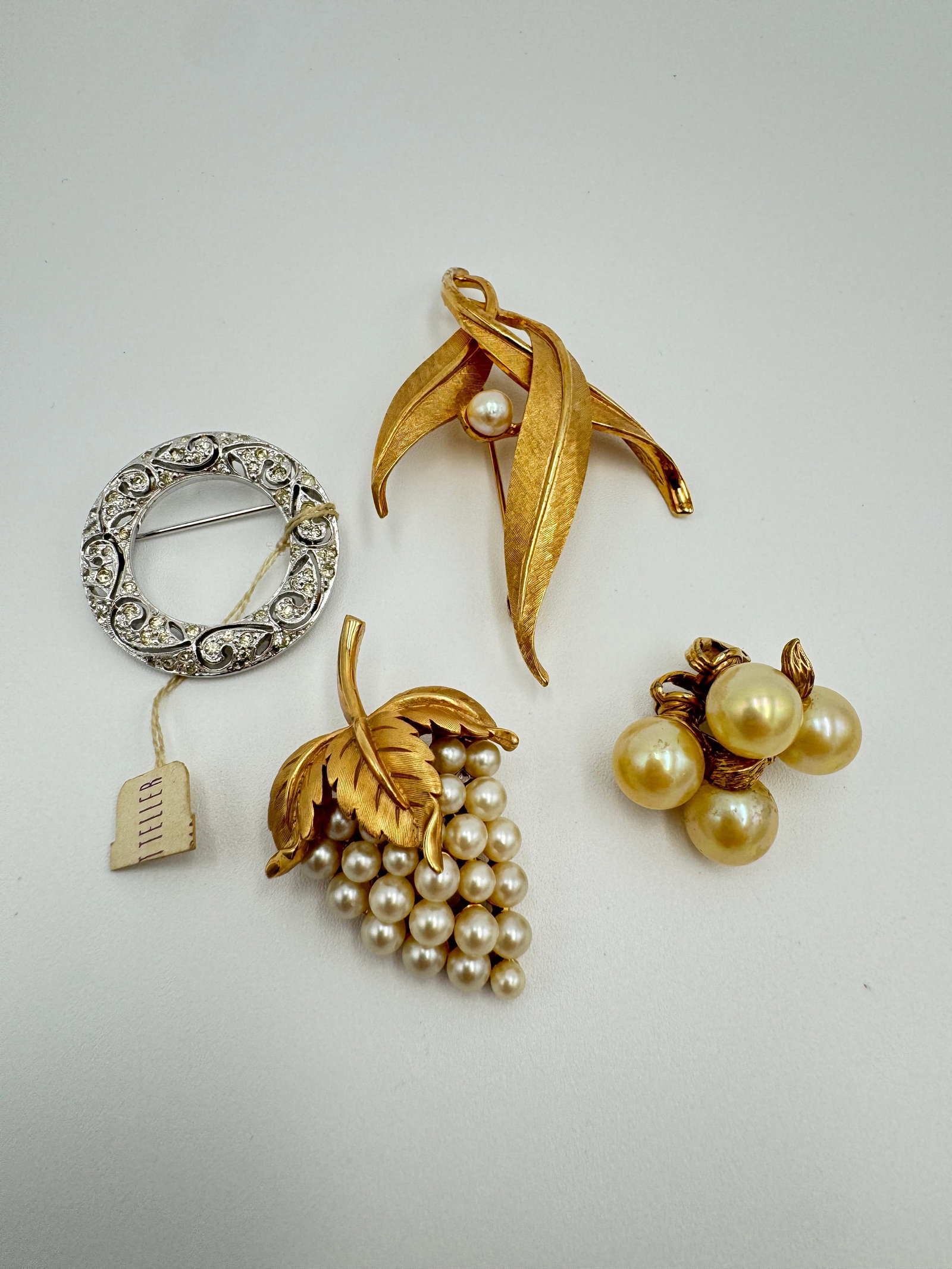 Vintage signed designer jewelry Panetta, Ciner, Boucher and Trifari: This jewelry lot includes signed clear rhinestones Panetta brooch measuring 1 1/4” long, signed Boucher gold tone brooch with faux pearls measuring 2.5” long, signed Trifari faux pearl bro