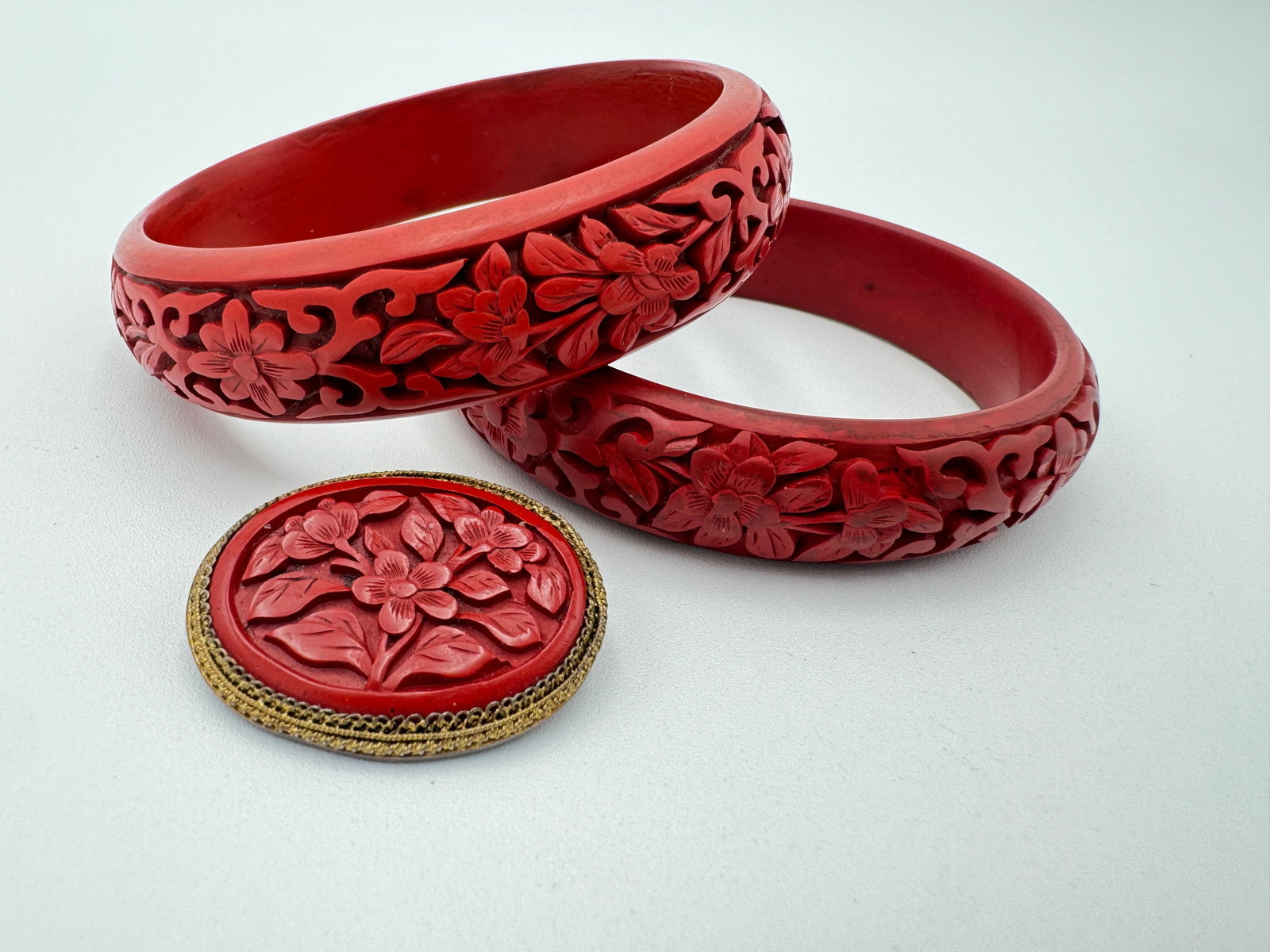 Vintage cinnabar carved bangles and brooch: Two vintage carved cinnabar bangles and cinnabar brooch. Brooch is measuring 1.5” long marked silver. See pictures for more details as they are the best description WE PROVIDE IN-HOUSE/COMBINED 