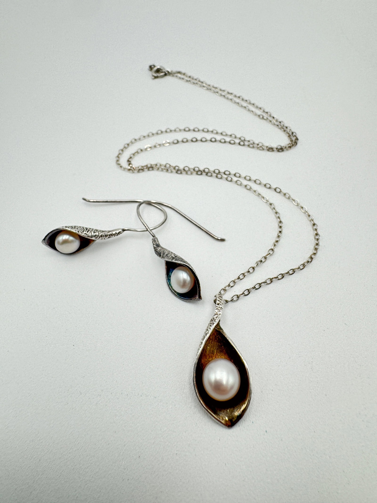 Calla Lilly and genuine pearl sterling silver necklace and earrings set: Calla Lilly and genuine pear sterling silver necklace and earrings set. Necklace is measuring 18” long with 1” long pendant, earrings are measuring 1.25” long. Stamped/tested. Total 