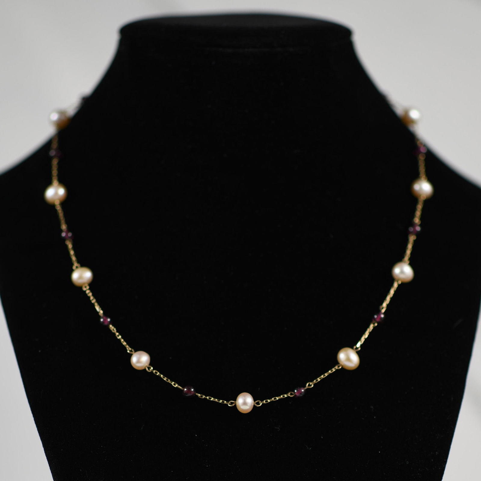 Vintage 10K Yellow Gold Pearl Necklace: This 10k yellow gold necklace features lustrous pearls interspersed with vibrant red garnet bead accents. The combination of classic pearls and striking red beads creates a harmonious and eye-catching