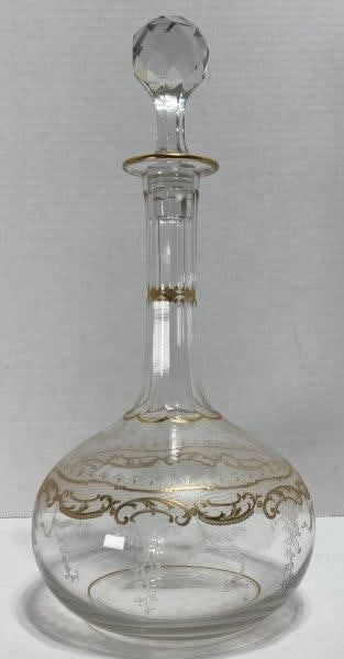 French Decanter: With faceted stopper and etched gold gilt scrollwork. Polished pontil. Measures 12"T (with stopper) x 5 1/2"W at widest top. In good condition. Shipping available.