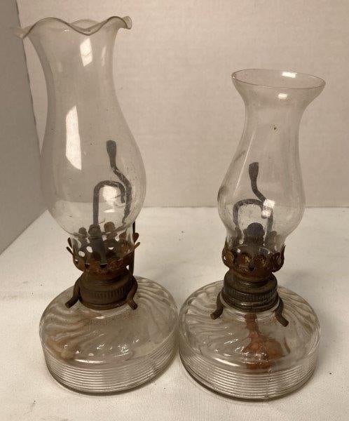 Pair of Miniature Oil Lamps: Measures 6 3/4"T x 3"W x 3 1/4"D. Missing one lamp chimney. With corrosion to burner and handle. Shipping Available.