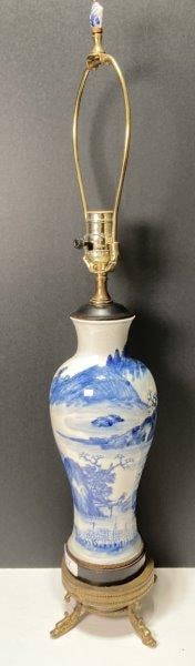 Chinese Blue and White Lamp: Chinese vase converted to lamp with footed base and figural dolphins. Decorated with mountain scene. Measures 19 1/2"T from base to top of socket. Will need to be rewired. Shipping Available.