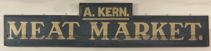 Large A. Kern Meat Market Wooden Sign: Large single sided advertising sign with gold lettering on matte black wooden background. Measures 31 1/2"H at highest point x 146"W. Overall good condition with age appropriate wear and missing trim.