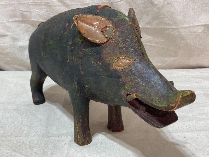 Folk Art Carved Pig with Copper Accents: This charming folk art carved pig features distinctive copper accents, including detailed eyes, ears, and a curled tail. Measures 10 1/2''T x 4''W x 16''D. Some loss to the paint. Shipping Available.