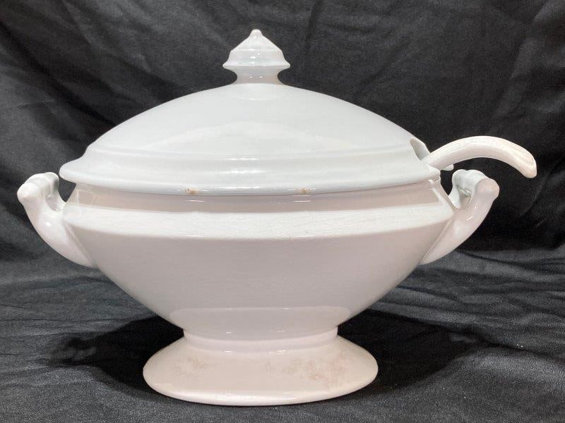 White English Ironstone Footed Tureen: Marked J & G Meakin, Covered top, Ladle. Measures 10 1/4''T x 13''W x 8 1/2''D. Discoloration to the ladle, Firing flaw on edge of lid, light discoloration and crazing. Shipping Available.