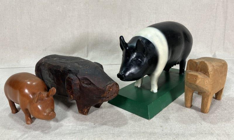 Four Folk Art Carved Pigs: Four folk art carved pigs, including one polychromed pig on a green wooden base, three additional whimsical pig carvings. Largest measures approx. 6''T x 3 1/2''W x 8 1/2''D. Some light wear to the pa