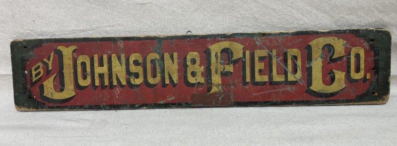 Johnson & Field Co. Painted Sign: A vibrant advertising sign painted on a wood board, featuring bold Johnson & Field Co. lettering in yellow, red, and green. Measures approx. 5 1/2'' x 28 1/2''. Some wear and a slight bend to the boar