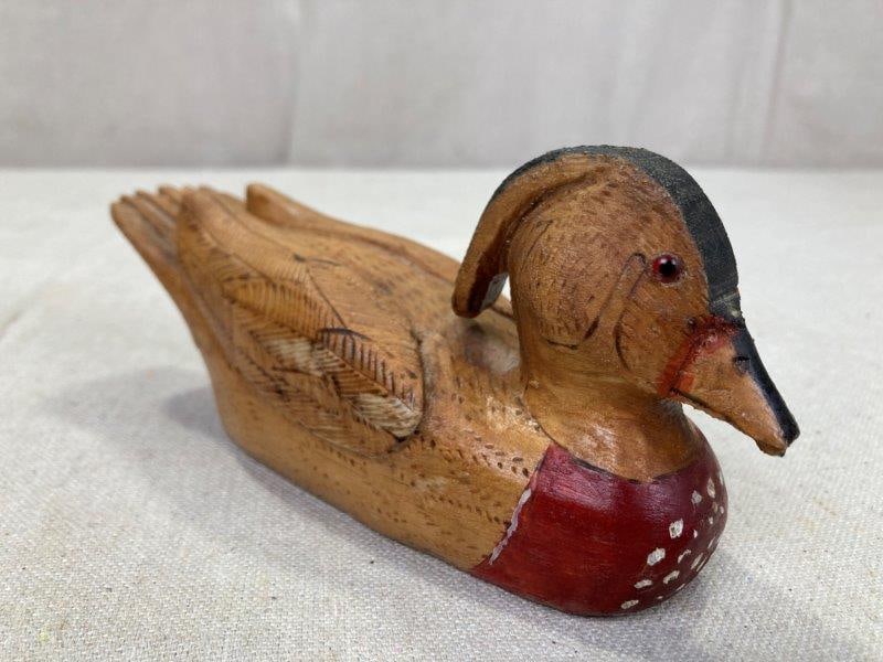 Folk Art Carved Wood Duck, Signed M.D. 1989: A charming hand-carved folk art duck featuring polychrome decoration on the front and incised feather work throughout. Signed M.D. 1989 on the base. Measures approx. 3''T x 6 1/2''L. Good condition. S