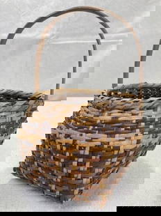 Cherokee Rivercane Gathering Basket: Tightly woven with a warm, aged surface in natural brown and tan tones, this traditional Cherokee gathering basket is compact yet finely crafted. Measures approximately 10 inches to the top of the