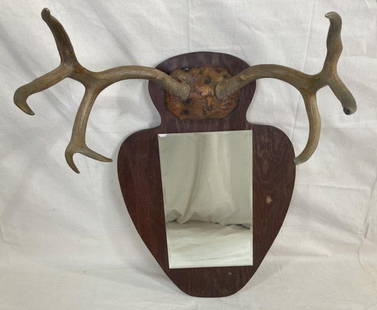 Large Mounted Antler Rack with Mirror: Impressive mounted antler rack featuring a spade-shaped cutout board with a mirror set below a bold set of antlers. Measures approx. 24 3/8''W x 34''H. Good condition. Shipping available. 
