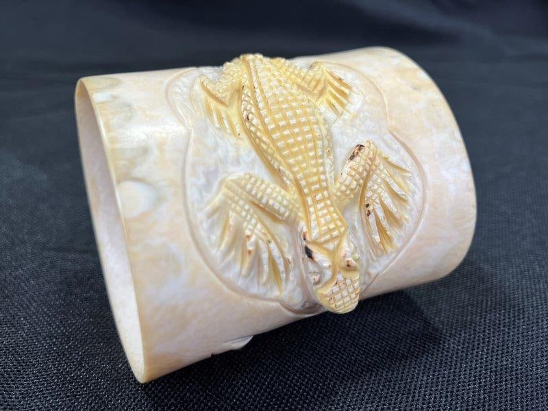 Folk Art Carved Bone Alligator Napkin Ring: Highly detailed folk art napkin ring carved from bone, featuring a full-body alligator perched atop the ring. Finely rendered with expressive detail and smooth finish. Measures approximately 1 3/4''T