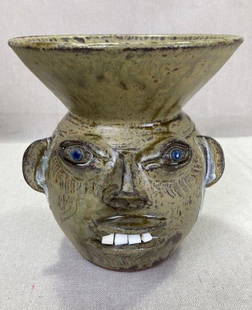 Walter Fleming Face Spittoon: Whimsical face spittoon by Southern folk potter Walter Fleming, featuring a vivid light green glaze, expressive sculpted features, bright blue eyes, and a wide toothy grin. Signed on the base.