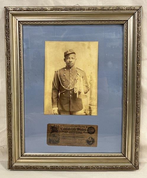 Framed Display of Buffalo Soldier with Confederate $500 Bill: Reproduction photograph of a Buffalo Soldier paired with a Confederate $500 bill, mounted together in a silver-tone frame. Measures approximately 18'' x 22''. Good condition with minor wear. Shipping 