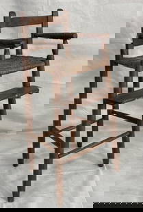 Southern Primitive High Chair: Early high chair featuring slightly turned arms, double-splat back, and a woven river cane seat. Displays classic Southern craftsmanship with a timeworn surface. Measures approximately 34''H x 14