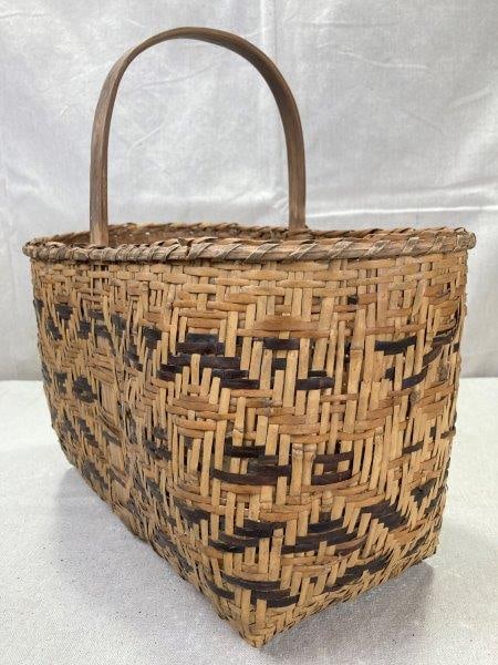 Cherokee Rivercane Market Basket: A well-used example with a warm aged patina, woven in natural tones of brown and tan rivercane. Generously sized and traditionally formed, it measures 15 inches to the top of the handle, 16 inches wid