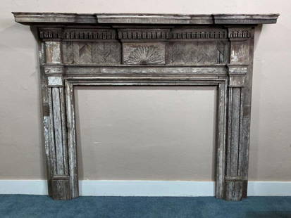 Southern Yellow Pine Fireplace Mantel: This grand Southern mantel features a carved central sunrise motif flanked by fluted columns, all topped with an intricately detailed overhanging cornice. Crafted with attention to architectural