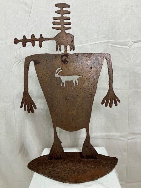 Southwestern Metal Sculpture: Expressive metal sculpture in a whimsical Southwestern style, featuring stylized form and a rich, weathered patina. Measures 22 3/4''H x 13''W x 7''D. Good condition with areas of surface rust. Shippi