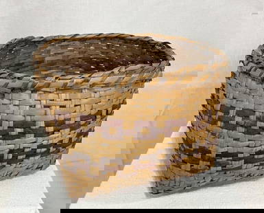 Cherokee Rivercane Basket: Beautifully woven Cherokee basket crafted from natural and dyed rivercane, featuring a traditional pattern and well-balanced form. Measures approx. 6 3/8''H x 8 1/2''W x 9''D. Rim possibly rewrapped.