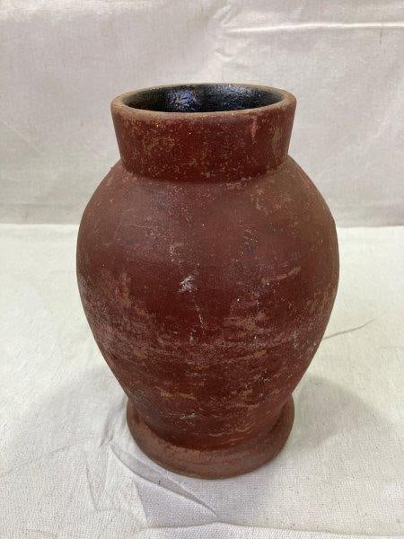 Southern Stoneware Vessel: Classic form with a rich reddish-brown glaze and subtle surface variations. Minor chip to the base. Measures approximately 9''H x 5 1/2'' in diameter. Shipping available.