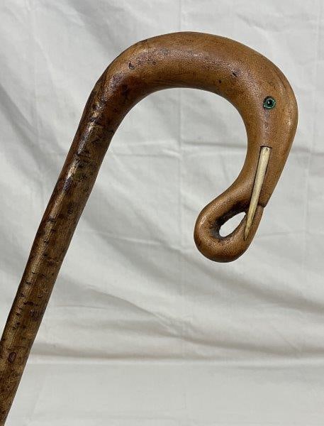 Carved Elephant Head Cane: Elegant cane featuring a finely carved elephant head handle with glass eyes and applied bone tusks. Curved handle over a tapered shaft. Measures approximately 36 1/4''L. Good condition with minor wear
