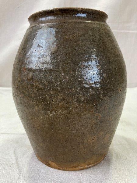 Southern Stoneware Storage Jar: Traditional Southern stoneware storage jar featuring a warm tan glaze accented with green drips.Measures approx. 8 1/2''H x 6''W. Displays tight cracks consistent with age. Shipping available.
