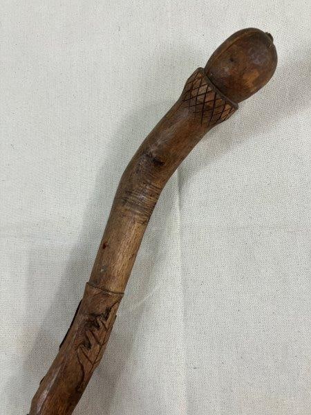 Folk Art Carved Cane with Acorn Handle and Floral Motifs: Charming folk art cane featuring a carved acorn-shaped handle and a thick shaft adorned with intricately carved flowers and leaves. Measures approx. 41''L. Small split in the handle. Shipping availabl