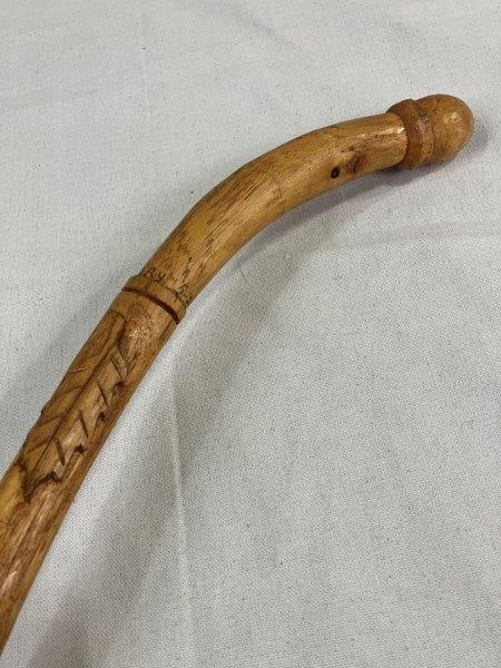 Folk Art Carved Hickory Cane: Beautifully carved folk art hickory cane featuring an acorn-form handle and carved leaves descending the shaft. Dated 5-20-85, this piece showcases fine detail and naturalistic charm. Measures approx.
