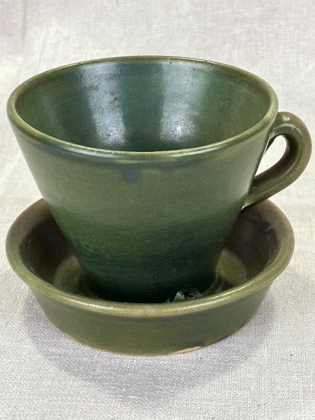 W.J. Gordy Tea Cup Planter: A whimsical form by renowned Georgia potter W.J. Gordy, this oversized teacup planter is finished in a rich green glaze and features two drainage holes at the base. Stamped "Georgia Art Pottery" on th