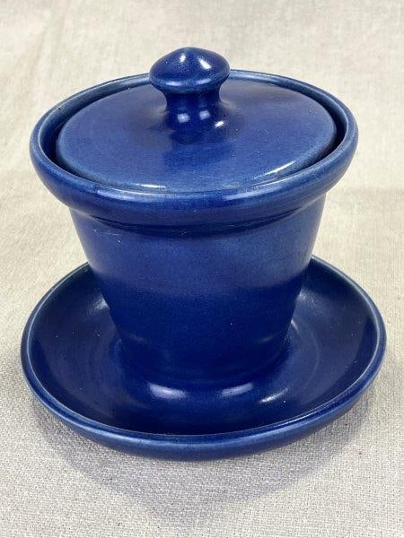 W.J. Gordy Mustard Jar with Underplate: A lidded jar in a striking dark blue glaze, accompanied by its original attached underplate. Georgia Art Pottery, stamped on the base. Measures approximately 3 1/2"H x 4 1/4" in diameter. Good conditi