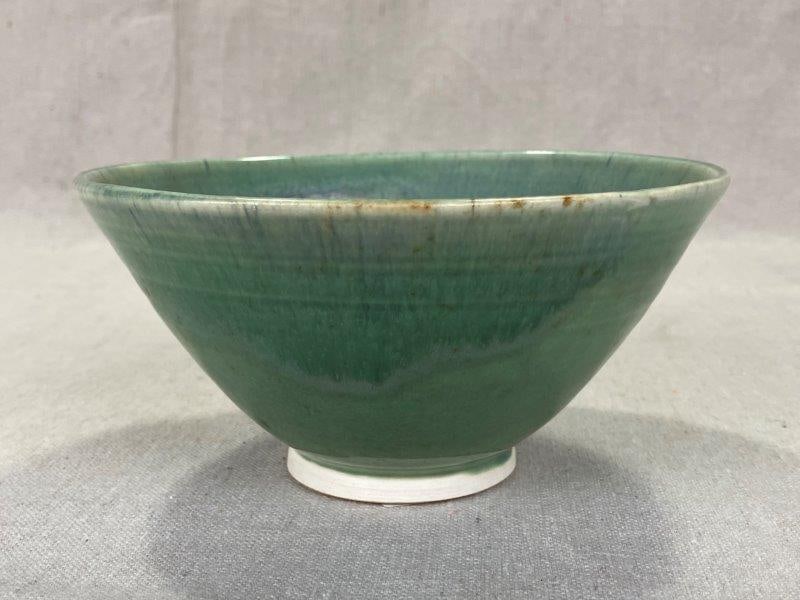 Studio Art Pottery Bowl: Hand-thrown with a softly flared rim, this bowl features a serene blend of light green and blue glaze. Impressed maker's mark on the base. Measures approximately 3"H x 6 1/4" in diameter. Good conditi