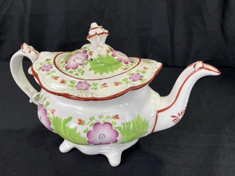 Decorated English Porcelain Teapot: Features an ornate primrose floral pattern with painted detailing throughout. Stamped with a "K" on the base. Measures approximately 7 3/4''T x 11''W x 6''D. Shows small chips on the lid, wear to the 