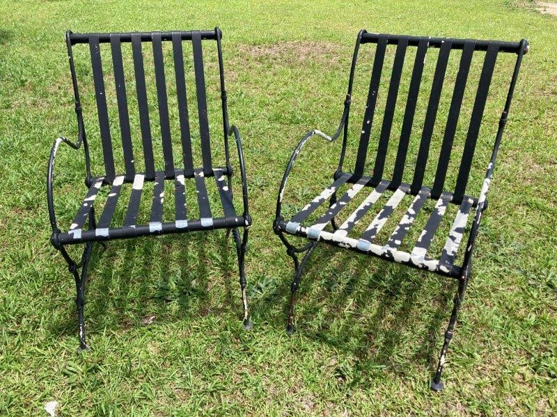 Pair of Painted Wrought Iron Patio Chairs: Pair of vintage wrought iron patio chairs featuring aluminum banding, floral accents, and sturdy construction. Each chair measures 31" H x 20" W x 21 1/2" D; 16" seat height. Painted finish with age-a