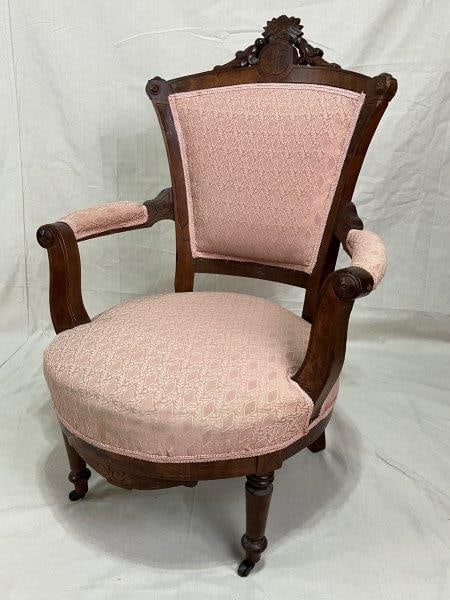 Carved Victorian Armchair: Featuring a burl walnut frame with a carved central crest, this elegant Victorian armchair has gracefully curved arms and turned front legs. Upholstered seat and back Measures approximately 41"H x 28"