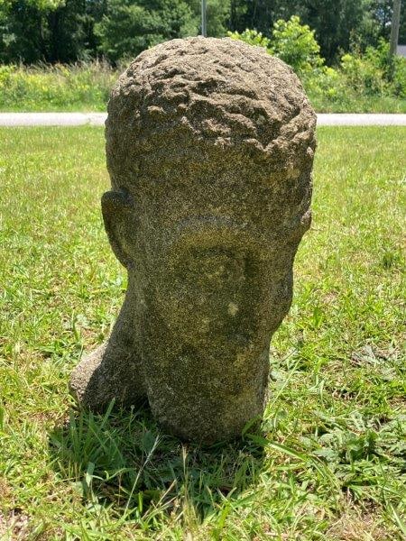 Concrete Garden Sculpture – Expressive Male Head: Concrete sculpture of a man's head with a downward gaze and expressive facial features, evoking contemplation or introspection. Statue measures 16" H x 10" W x 7" D. Weathered surface with discolorati