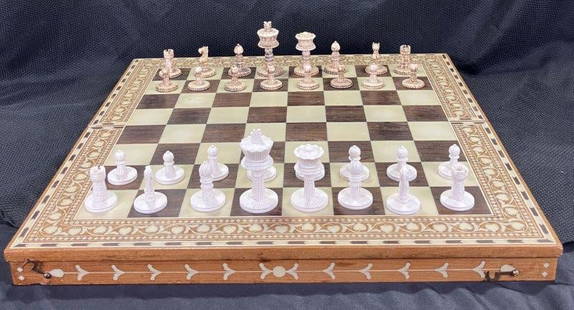 Fine Inlaid Chess Board with Carved Pieces: Features intricate bone inlay and finely carved chess pieces, showcasing skilled craftsmanship. Board measures approximately 1 1/2'' H x 20'' W x 20'' D. Condition: Good with some light wear. 