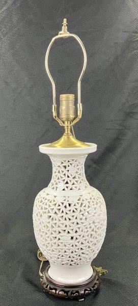 Chinese Pierced Porcelain Lamp: A decorative Chinese porcelain lamp featuring finely painted floral motif patterning and delicately pierced openings throughout the body. Mounted with brass fittings, the lamp combines elegant craftsm