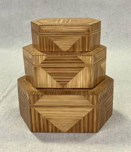 Set of Chinese Marquetry Nesting Boxes: A decorative set of three Chinese nesting boxes, each crafted in a hexagonal form with intricate geometric marquetry patterns in contrasting light woods. The largest box measures approximately 2 1/2"
