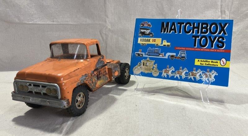 Tonka Truck & Matchbox Toys Collectorâ€™s Guide by Schiffer Publishing: A vintage USA-made Tonka truck featuring a bright orange body and rugged construction, paired with Matchbox Toys by Nancy Schiffer (Schiffer Publishing, 1994). The illustrated collectorâ€&#