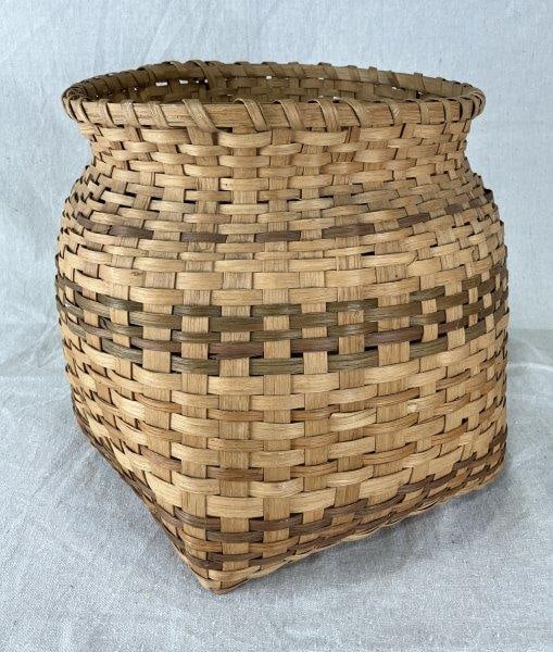 Cherokee Burden Basket: Finely woven with traditional craftsmanship, featuring a wrapped rim and subtle coloration throughout. Measures approximately 10 1/2'' H x 10 7/8'' W x 10 3/8'' D. The splint remains in good condition