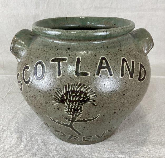 Jim Bozeman Decorated Thistle Pot Scotland Forever: Folk art stoneware pot by potter Jim Bozeman, decorated with a raised thistle motif and inscribed “Scotland Forever.” Measures approximately 9" H x 9 1/8" W x 8 5/8" D. Good condition.