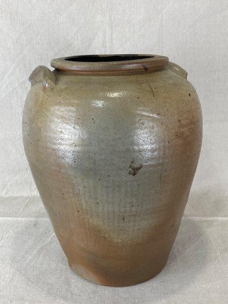 Stoneware Storage Jar: Beautiful buff-toned body with applied lug handles and an incised 4 denoting storage capacity. Robust form measuring approximately 16" H x 11" in diameter. Exhibits age-appropriate wear, including som