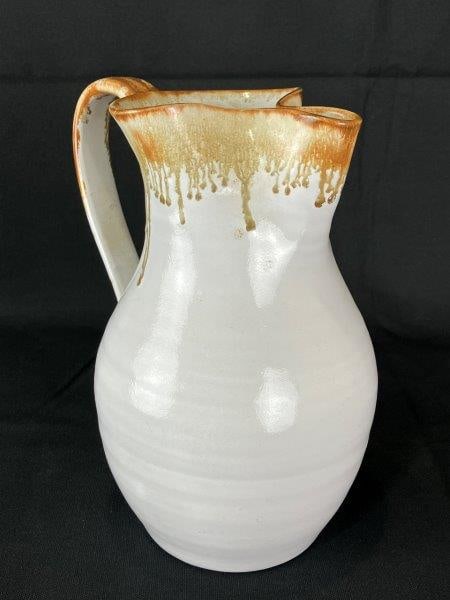 J.B. Cole Stoneware Pitcher, 1996: Distinctive pitcher crafted in the Seagrove, NC tradition by a member of the renowned Cole family of potters. This graceful form features a pristine white body accented with flowing brown glaze drips