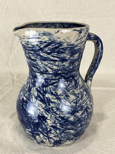 Jerry Brown Blue and White Stoneware Pitcher: Southern folk potter celebrated for his distinctive traditional forms. This example features characteristic cobalt blue decoration over a white glaze, with a classic, robust pitcher shape. Measures ap