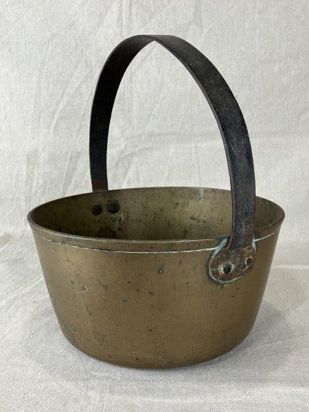 19th-Century Brass Bucket: Heavy brass bucket with iron handle. Measures approximately 12 1/2" H x 10 1/2" in diameter. Good condition with age-appropriate wear.