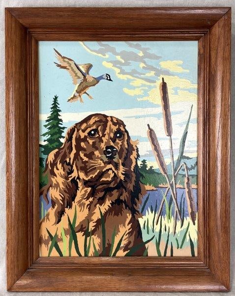Vintage Hunting Dog Painting: Charming paint-by-number portrait of a brown hunting dog, set against a natural backdrop with cattails and a duck in flight. Measures approximately 19 5/8" H x 15 5/8" W x 1 3/4" D. Good condition
