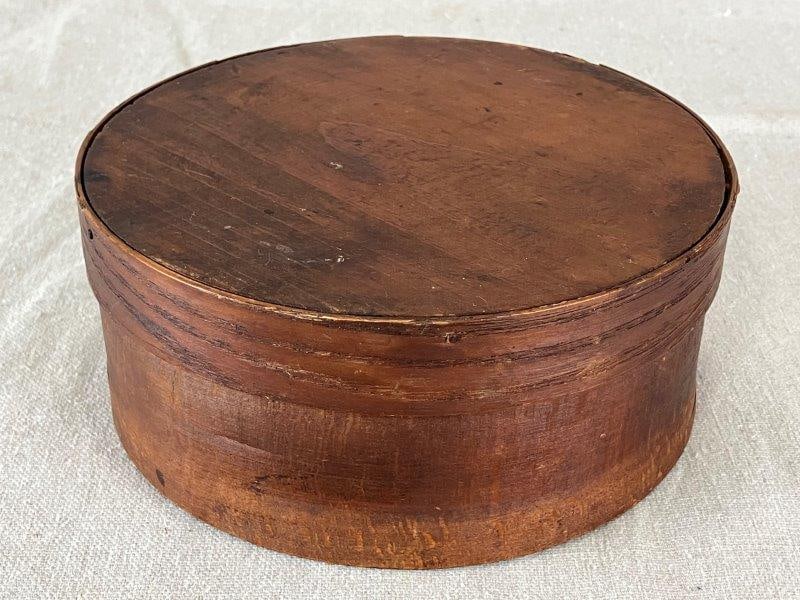Pantry Box: Classic round pantry box with a warm, aged finish. Measures approximately 2 3/4" H x 6 1/2" in diameter. Good condition with light wear consistent with age.